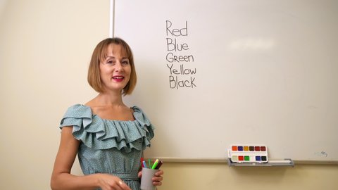 Teaching colors and English for kids teacher at whiteboard 