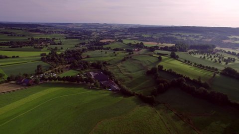 Valley landscape, campsites and forests,  scenic rolling hills, farmlands, natural pastures, meadows and farms, with rural roads. Blue and purple sky in the background. Drone Aerial View South Limburg