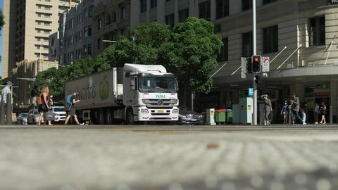 SYDNEY, NSW, AUSTRALIA. DECEMBER 18 2020. Commuters pass Woolworths lorry in Sydney, slow motion.