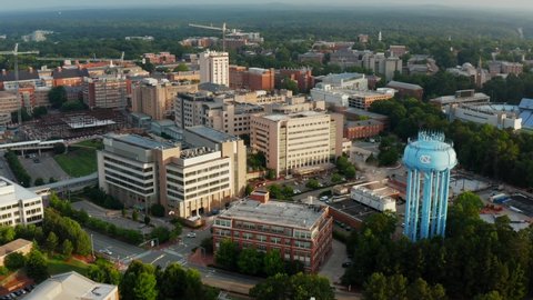 Chapel Hill , NC , United States - 06 13 2021: Beautiful UNC University of North Carolina establishing shot, golden hour aerial. Water tower and football stadium.