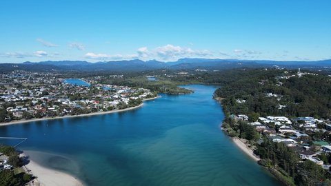 High scenic panorama of Tallebudgera Creek bridge with the Gold Coast hinterland in the foreground. Moving drone view
