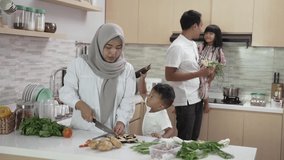 muslim family with two children cooking together at home preparing for dinner and iftar break fasting