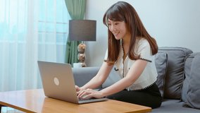 Beautiful young woman wearing headset is making video conference call via computer at home 