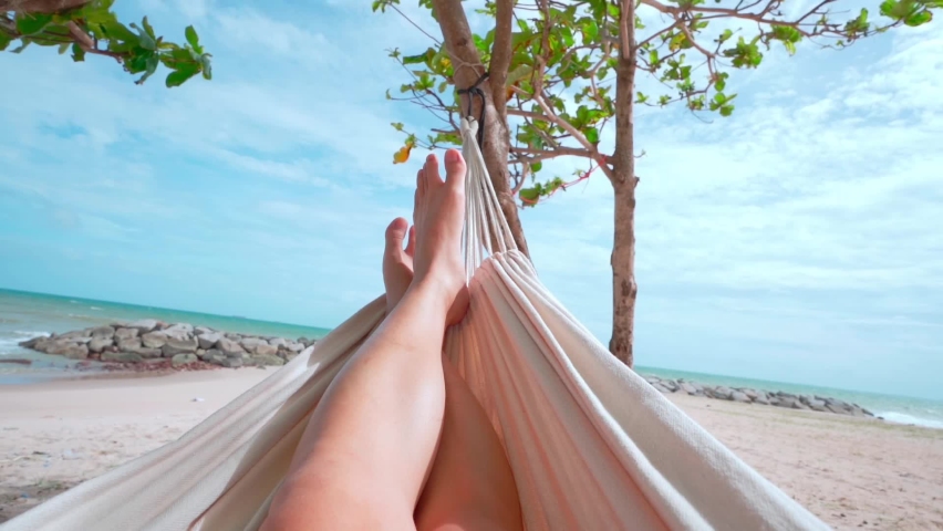 Hello Summer man relaxing in hammock tanning on the beach happy sunbathing during summer holidays. on tropical vacations. Royalty-Free Stock Footage #1076632106