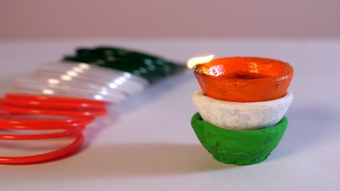 Orange, white, green bangles, Tricolor Diya kept together on Independence Day Republic Day. A tri-color oil lamp and bangles kept on a table - Independence Day celebrations