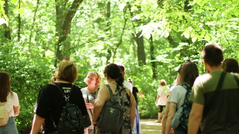 Askania Nova, Ukraine, June, 16, 2021: A group of tourists with a guide walk through the Askania reserve listening to a lecture on plants and rare species of trees