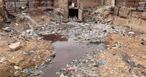 NIMA, GHANA - 20 JUL 2021: Nima Accra city toxic environment pollution poverty neighborhood. West Africa. towns, villages communities polluted by trash, garbage and sewage. Plastic, industrial, sewer.