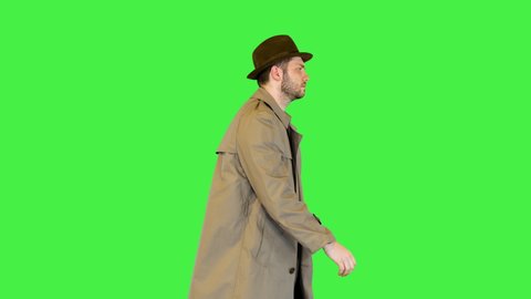 Serious man investigator classic private detective officer or retro police inspector in coat walking on a Green Screen, Chroma Key.