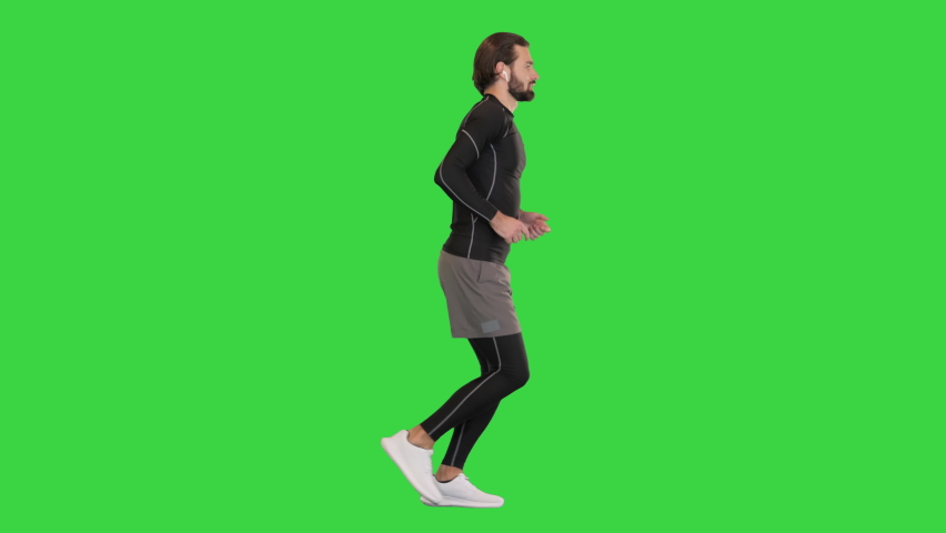 Runner Man In Sportswear Exercising Jogging on a Green Screen, Chroma Key. Royalty-Free Stock Footage #1076644136