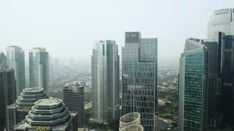 JAKARTA - Indonesia. July 23, 2021: Aerial view of misty Jakarta city with skyscrapers during lockdown periods (PPKM Darurat). Shot in 4k resolution