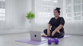 Plus size women are exercising online to lose weight in the living room, concept of maintaining health.
