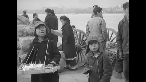 1951 - South Korean refugees of all ages wait with their baggage on a pier in Busan.