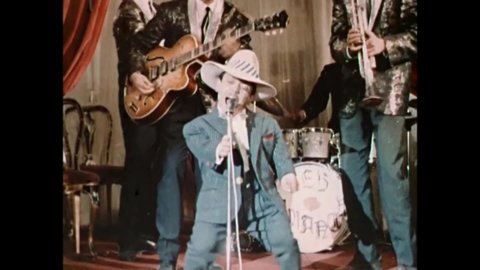 1964 - In this exploitation movie, a little person is the front man for a band and dances and does singing impersonations (narrated by Boris Karloff).