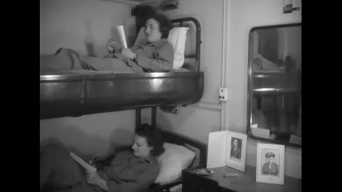 1944 - Two WACs read books in their bunks on a troop transport.