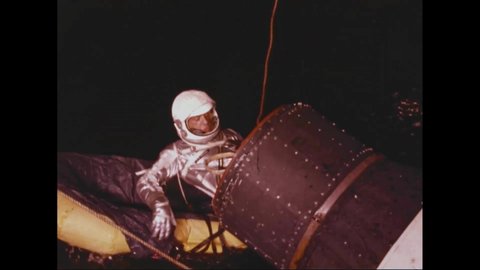 1962 - Alan Shepard gets out of an egress capsule and onto an inflatable raft in a testing water tank.