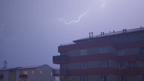Natural phenomenon of lightning in sky over house. Flashes light accompanied mountain beginning hurricane in city beginning rain. CZ, Kladno, 18.7.2021.
