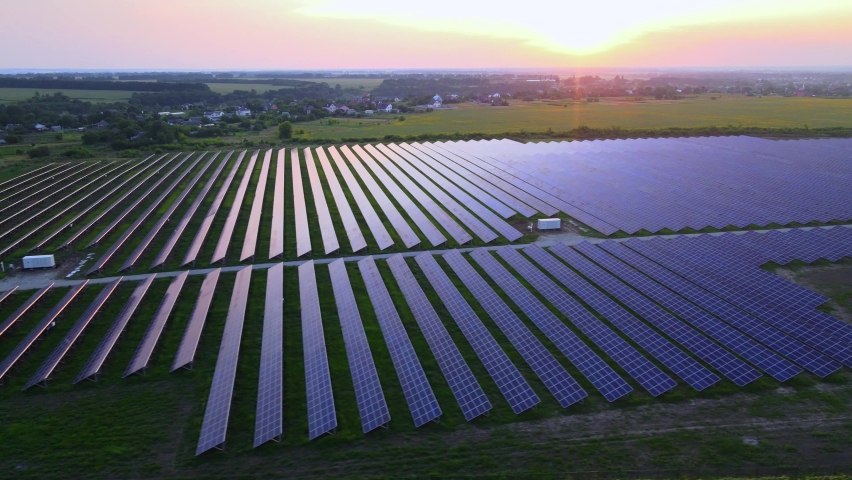 Aerial drone view into large solar panels at a solar farm at bright sunset. Solar cell power plants. HDR footage video 4k. Royalty-Free Stock Footage #1076668436