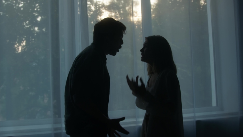 Silhouettes of man and woman shouting at each other, couple quarreling in the evening at home husband and wife screaming. Scandal and crisis in family. Domestic violence, abuse. | Shutterstock HD Video #1076670893