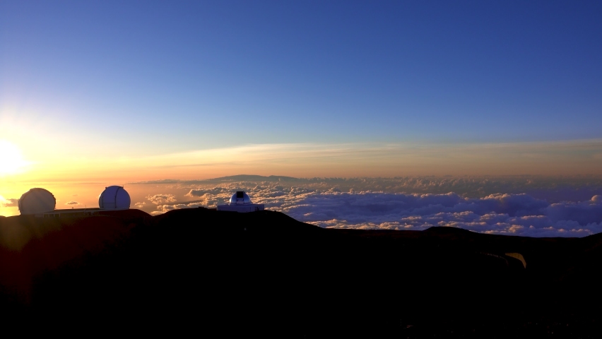 The observatory in a sea of sunset clouds. Mauna Kea Observatory, Big Island, Hawaii, U.S.A. June 2019.