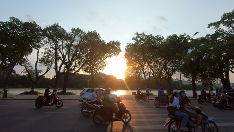 Busy motorcycle traffic with sunset. Hanoi, Vietnam