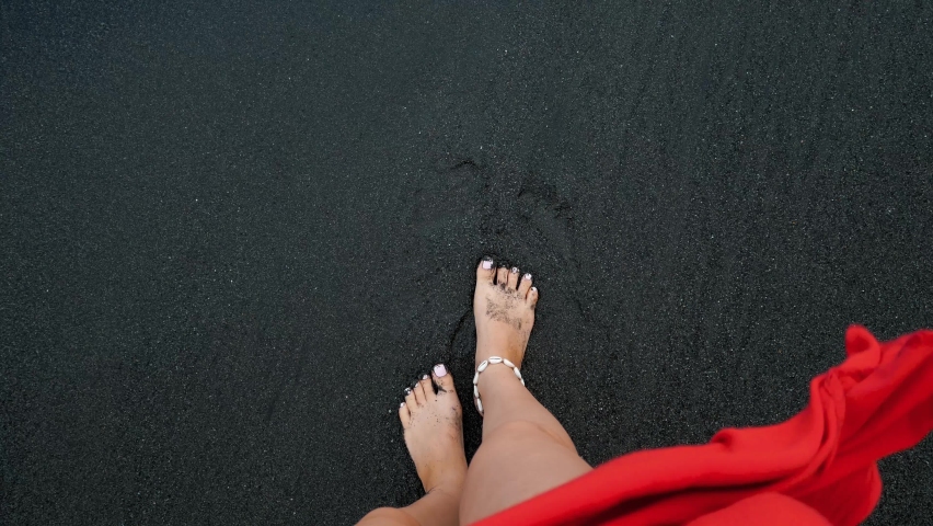 Woman walks on the black sand beach first person view on legs in Bailan beach Bali. High quality 4k footage | Shutterstock HD Video #1076682329