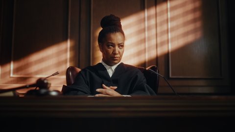 Cinematic Court of Law Trial: Portrait of Impartial Thoughtful Female Judge Looking at Camera. Wise, Incorruptible, Fair Justice Doing Her Job Professionally, Sentencing Criminals, Protecting Innocent