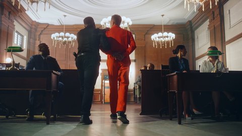 Cinematic Court of Law and Justice Trial Proceedings: Portrait of Accused Male Criminal in Orange Jumpsuit Led Away by Security Guard in Front of Jury. Convict Sentenced to Serve Jail Time.