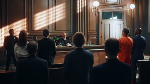 Court of Law and Justice Trial: Imparcial Honorable Judge Pronouncing Sentence, Striking Gavel. Cinematic Shot of Male Lawbreaker in Orange Robe Sentenced to Serve Time in Prison. Hearing Adjourned,