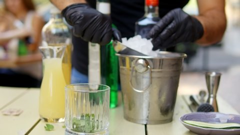 Professional bartender preparing a cocktail with ice. Bartender  combining ingredients and making cocktail

