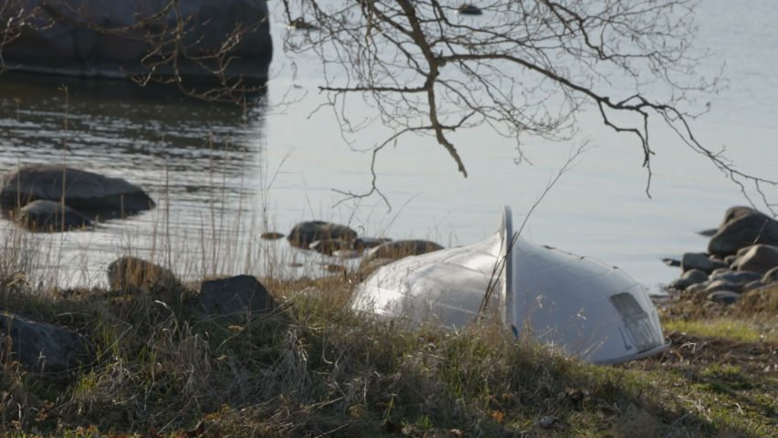 An upside down boat on the side of the lake laying on the grass in Estonia