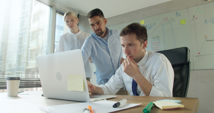 Stressed shocked diverse workers office team frustrated about business failure reading bad news results or email looking at laptop, depressed upset colleagues having problem | Shutterstock HD Video #1076706812