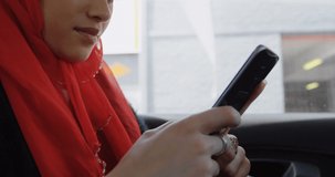Animation of asian woman in hijab using smartphone over cityscape. communication technology and keeping in touch, digitally generated video.