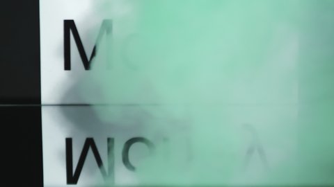 Reverse close up shot of wisps of green smoke flowing around sign with word Money, then clearing away