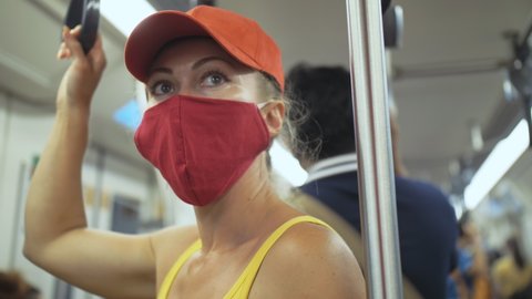 Woman travel caucasian ride at overground train airtrain with wearing protective medical mask. Girl tourist at airtrain with respirator. People mask.