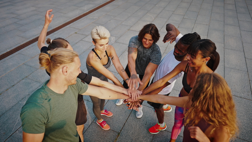 Team of athletes, men and women, stand in a circle and shake hands. Group of like-minded people. Group hand shake. Royalty-Free Stock Footage #1076730251