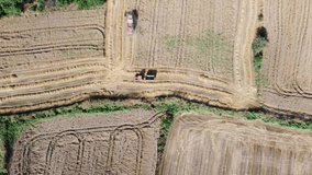 harvester and tractor,a harvester cropping the field with a tractor behind it.Aerial farmland footage.
