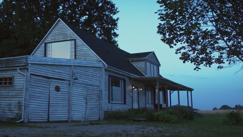 HANDHELD WIDE Establishing shot of a facade of East American style residential house at dusk. Shot with 2x anamorphic lens