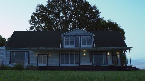 HANDHELD WIDE Establishing shot of a facade of East American style residential house at dusk. Shot with 2x anamorphic lens