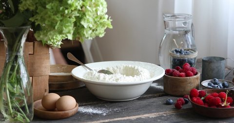 Woman adds sugar, salt, eggs the dough with spatula to make pierogi step-by-step recipe