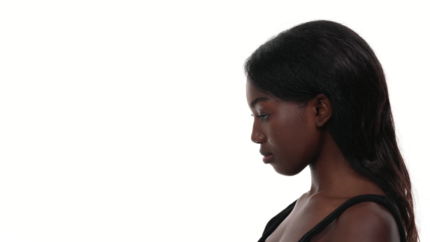 Side view of an African woman, with her head down and a caucasian male hand raising it up. Isolated on white background. Royalty-Free Stock Footage #1076750756