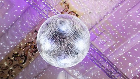 Disco mirror ball. Sparkling disco ball. Concept of night party. Disco ball with bright rays, night party background. Silver Mirror Disco ball with bright rays