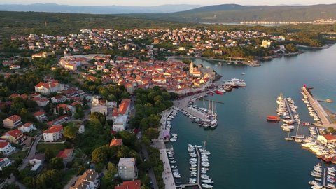 Aerial drone footage of the medieval Krk old and and marina in Krk island in the Adriatic sea in Croatia at sunset