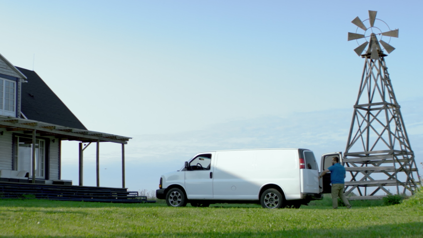 WIDE HANDHELD Hispanic male delivering package, bringing box from van to a house. White van with copy space. Shot with 2x anamorphic lens | Shutterstock HD Video #1076760845