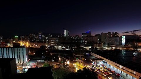 Porto Alegre, Rio Grande do Sul, Brazil - 07.27.2021 - Sunset aerial time lapse of lights traffic at intersection. Time lapse  of dowtown city of Porto Alegre, Rio Grande do Sul. Sunset sky time lapse