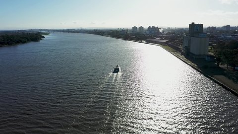 Porto Alegre, Rio Grande do Sul, Brazil - 07.27.2021 - Aerial landscape of boat sailing at Guaiba River, landmark of downtown city of Porto Alegre, Rio Grande do Sul, Brazil.  Sailing boat at Guaiba.