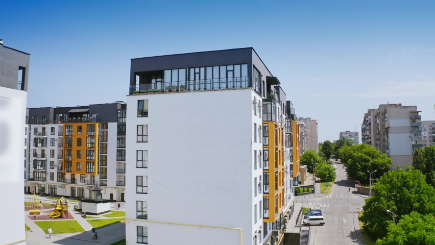 Urban background in sunny daytime. Exterior of a new apartment building. Modern design of high-rise building with large windows and balconies. Royalty-Free Stock Footage #1076767274