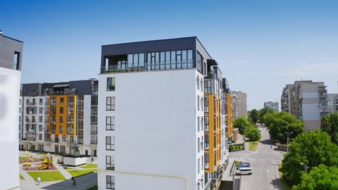 Urban background in sunny daytime. Exterior of a new apartment building. Modern design of high-rise building with large windows and balconies.