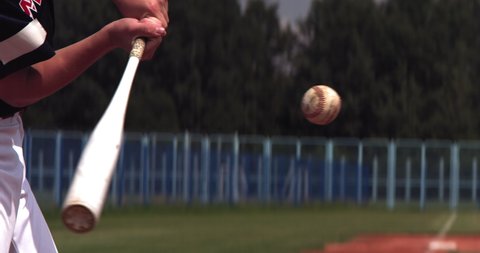 Kid boy batter baseball player fails to hit a ball over a home plate. Super slow motion, shot with high speed camera at 420 FPS 