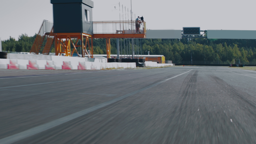 TRACKING Two teenagers pro racers driving their karts on a race track. Shot with 2x anamorphic lens Royalty-Free Stock Footage #1076768444