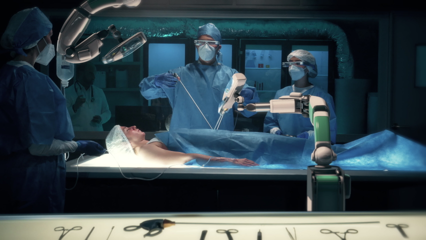 Team of surgeons wearing special augmented reality glasses perform a delicate operation using medical surgical robot arms. Modern medical equipment. Robotic arm for minimal invasive surgery. | Shutterstock HD Video #1076770385